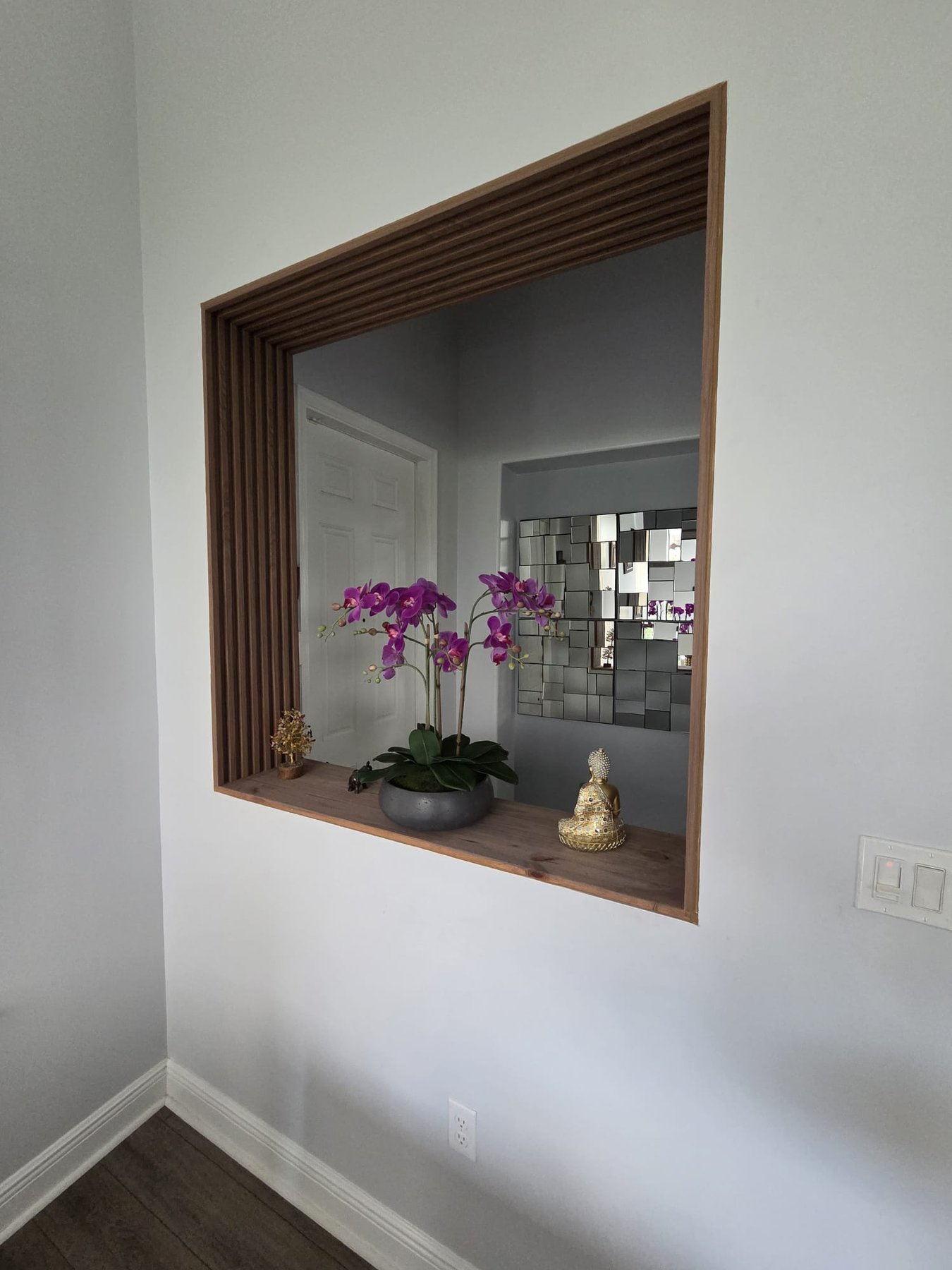 Wood-slat entrance opening with a decorative display ledge
